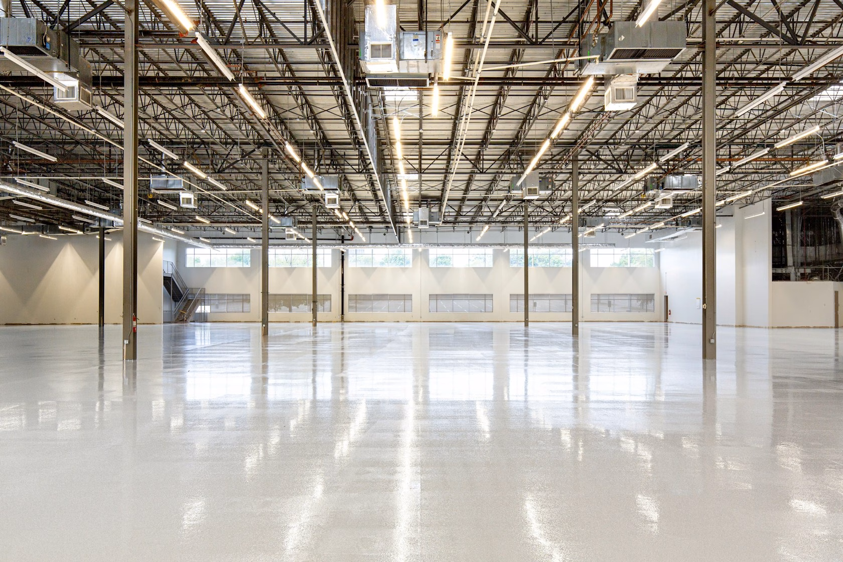 Interior de una nave industrial moderna y vacía con suelo de hormigón pulido