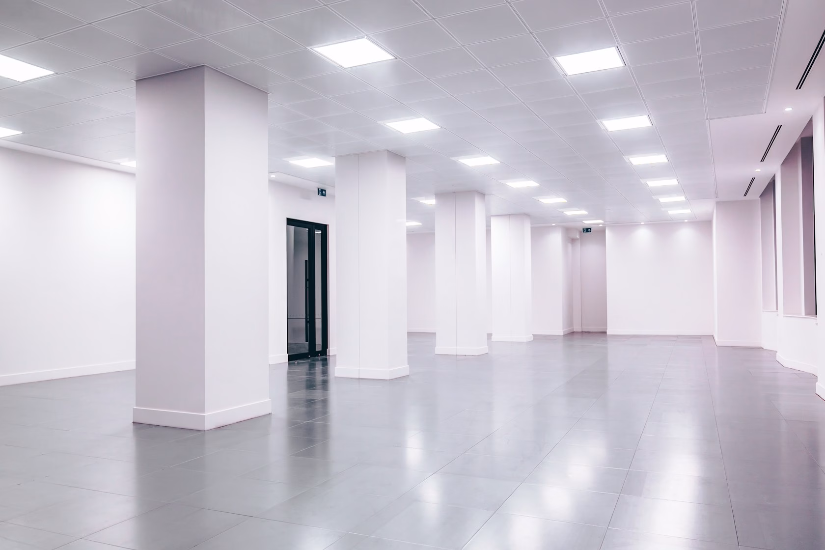 Espacio de oficina vacío con paredes blancas y puerta negra, estilo minimalista